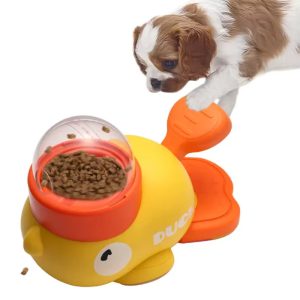 Spaniel puppy pawing the tail of a duck-shaped slow feeder filled with kibble